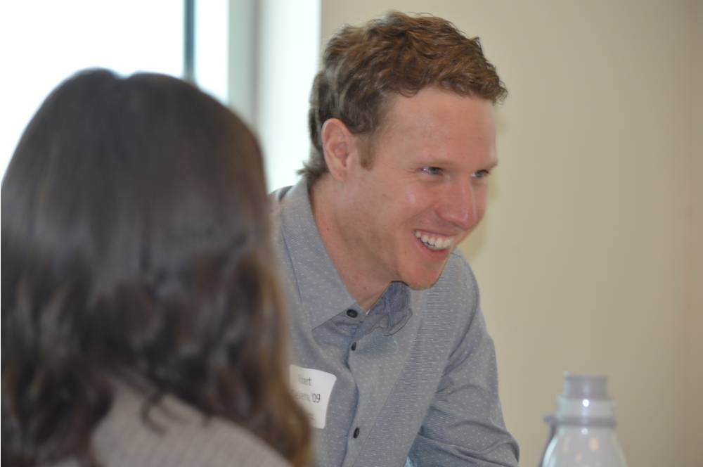 An alumnus smiling at the 30 Minute Mentors Event